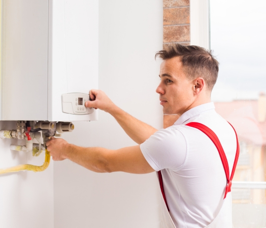 man installing tanlkless water heater